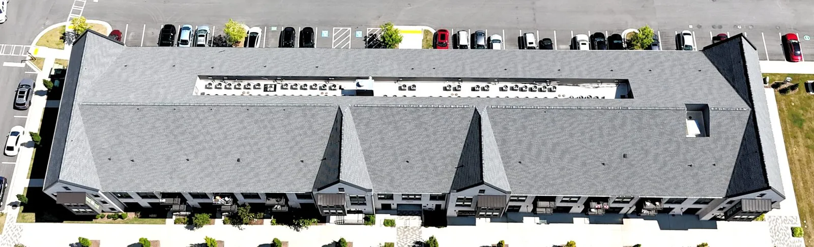 Close aerial view of new architectural shingles running along a roof ridge